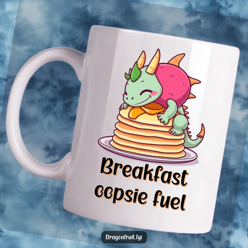 Funny mug showing a dragonfruit sheepishly grinning as it topples a tall stack of pancakes, creating a humorous breakfast scene.