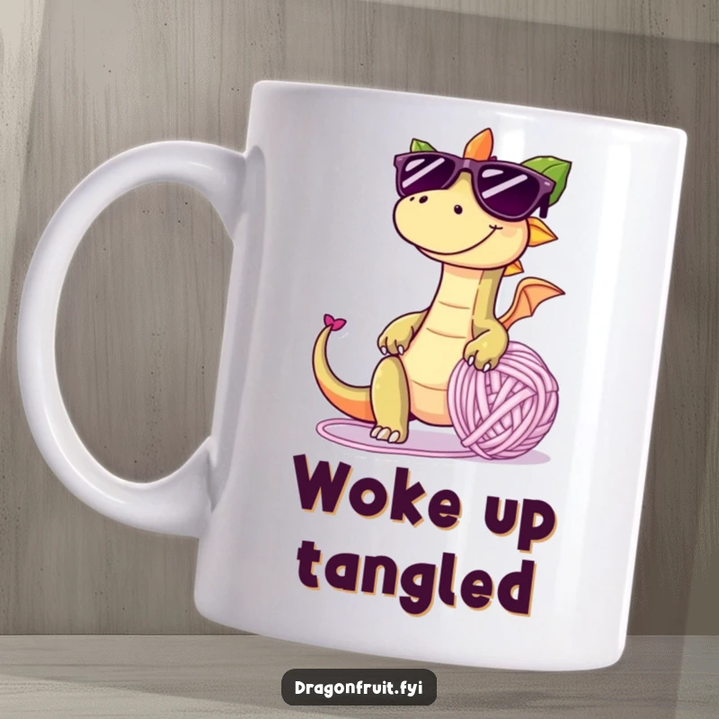 Funny mug showing a dragonfruit with oversized sunglasses and mischievous grin, tripping over a giant yarn ball, embodying playful chaos.