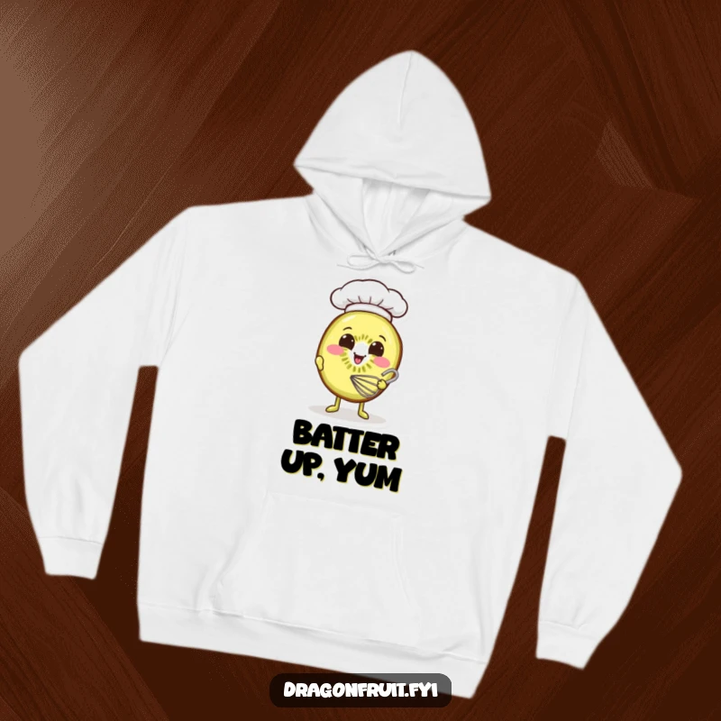 Funny hoodie featuring a smiling kiwi slice wearing a miniature chef hat, diligently whisking batter with a happy expression.